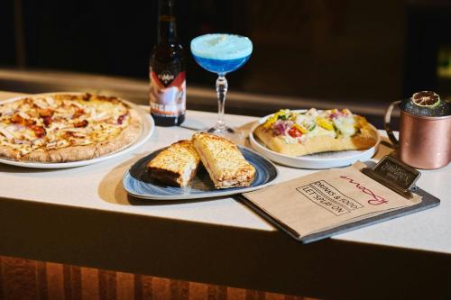 a table with three plates of food and a drink at Moxy Annecy in Annecy