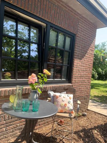a table with a vase and flowers on a patio at Vakantiehuis ABEL in Dilsen-Stokkem