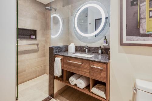a bathroom with a sink and a mirror at Fiesta Inn Suites Aeropuerto del Bajío in Silao