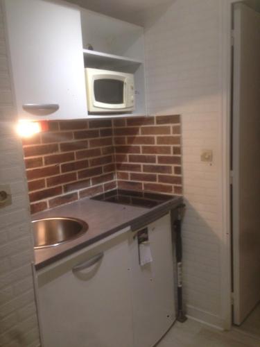 une cuisine avec un évier et un micro-ondes dans l'établissement Cozy seaside and comfortable apartment, à Saint-Malo