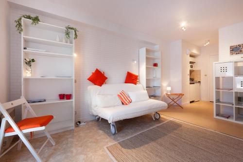 une chambre avec un lit blanc et une chaise dans l'établissement Cozy seaside and comfortable apartment, à Saint-Malo