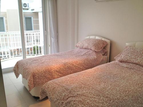 two twin beds in a room with a window at Villa Carolina The Royal Links Sarigerme, Ortaca in Sarigerme