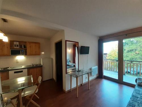 Il comprend un salon avec une table et une cuisine avec un balcon. dans l'établissement Chalet Florence - 3 Pièces pour 6 Personnes MAE-2011, à Modane