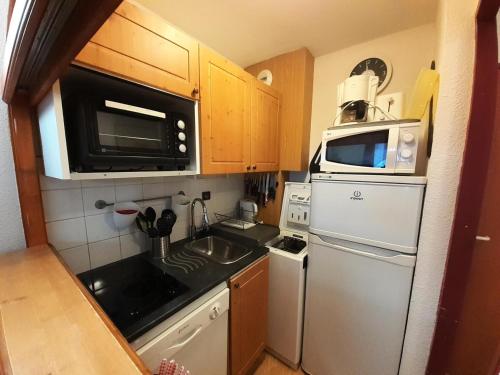 une petite cuisine avec un réfrigérateur et un micro-ondes dans l'établissement Résidence Chaviere - Studio pour 4 Personnes MAE-4581, à Modane