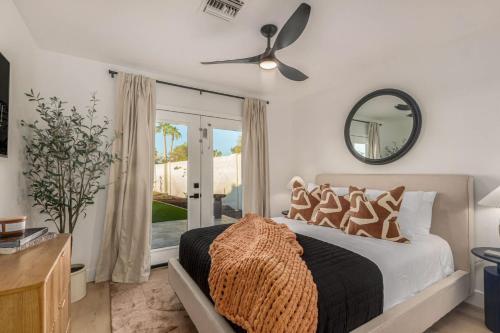 1 dormitorio con 1 cama con ventilador de techo y espejo en NEW - The Palmcroft Golf Escape, en Scottsdale