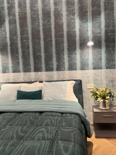 a bedroom with a green bed with a wall at SKY LUXURY Rooms Nettuno in Nettuno