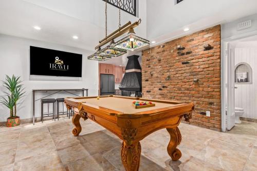 a pool table in a room with a brick wall at The Historic Desert Rose Villa in Tempe