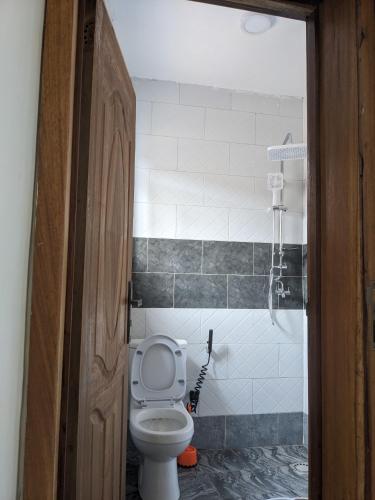 a bathroom with a toilet and a shower at Volcanoes Stay Musanze in Kigali