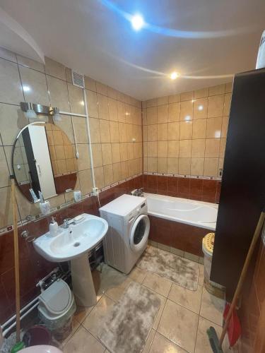 a bathroom with a sink and a toilet and a tub at Apartament Gabriela in Vulcan