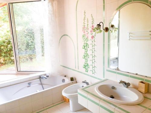 une salle de bain avec une baignoire, des toilettes et un lavabo dans l'établissement Villa Amapola, familiale et calme, à Lacanau