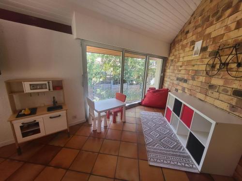 une cuisine avec une table et un mur en briques dans l'établissement Villa Amapola, familiale et calme, à Lacanau