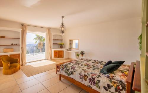 une chambre avec un lit et une grande fenêtre dans l'établissement Spectacular house, à Vence