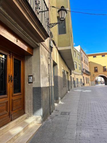eine leere Straße mit einer Holztür an einem Gebäude in der Unterkunft ESTUDIO con TERRAZA in Caravaca de la Cruz