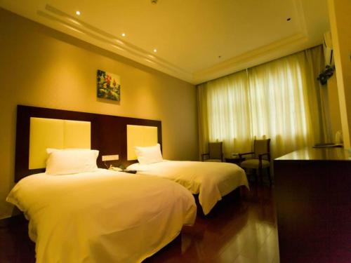 a hotel room with two beds with white sheets at GreenTree Inn Beijing Shunyi Xinguozhan Express Hotel in Shunyi