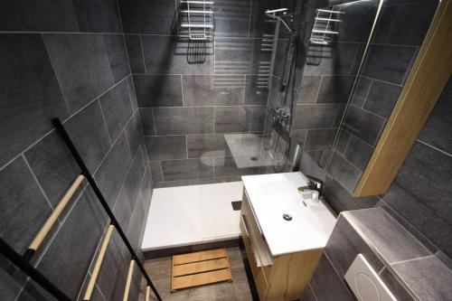 une salle de bain avec un lavabo blanc et une douche dans l'établissement Résidence Le Serro Torre - 2 Pièces 5 pers - LE CERRO TORRE - PLAGNE CENTRE MAE-6074, à Aime La Plagne
