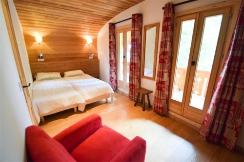 Un dormitorio con una cama y un sofá y ventanas. en Chalet L'alpicois - Chalet L'ALPICOIS 10 pers - PLAGNE CENTRE -wifi - MAE-3584, en Aime La Plagne