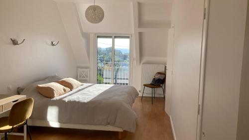 une chambre blanche avec un lit et une fenêtre dans l'établissement Villa Cancale, vue mer, 15 pers, plage à 200m, à Cancale