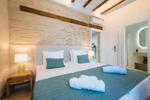 a bedroom with a large white bed with blue pillows at New Hostly Arenal in Seville