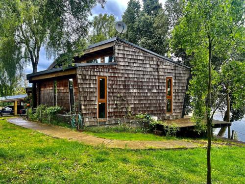 a small house sitting on the side of a lake at La Casa Del Lago in Puerto Octay