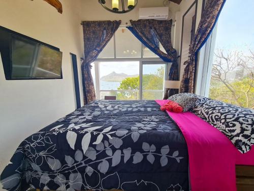 a bedroom with a black and white bed with a window at ONYX-- A Gem at DEE'S PEARL in Carriacou