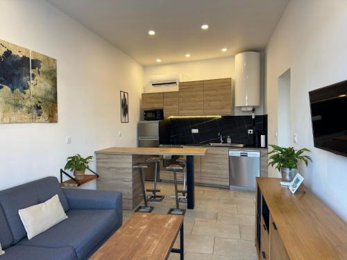 un salon avec un canapé bleu et une cuisine dans l'établissement Le Repos des Pins, à 10 minutes des plages, à Soustons