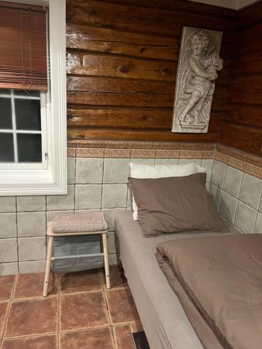 a room with a bed and a stool and a window at Lillesand sentrum unique accommodation in Lillesand