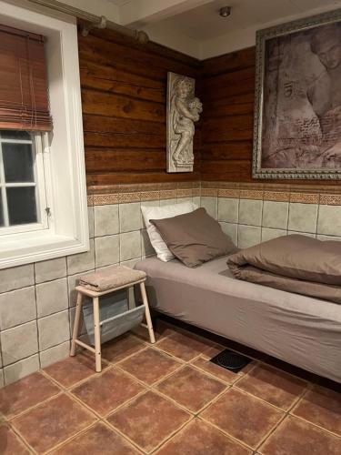 a bedroom with a bed and a stool in it at Sentrum Lillesand unique accommodation in Lillesand