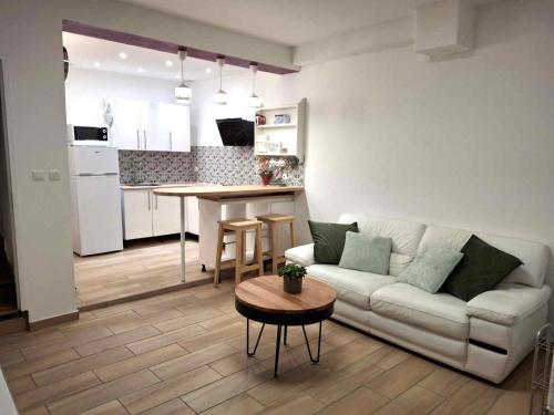 un salon et une cuisine avec un canapé et une table dans l'établissement La maison d'Emmie 83m2 avec WI-FI, à Valréas