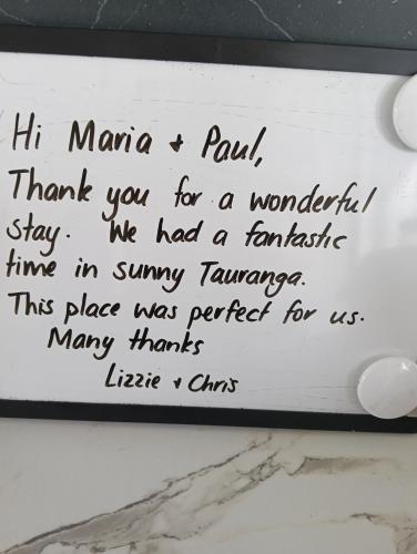 a sign on a wall with writing on it at Omanu Cottage in Mount Maunganui