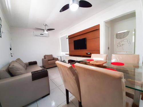 ein Wohnzimmer mit Esstisch und Fernseher in der Unterkunft Bate & Volta - Apartamentos com 2 quartos próximo ao SESC Bertioga in Bertioga