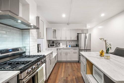 a large kitchen with white cabinets and stainless steel appliances at New 1-BD in Prime Philly Location with King Bed in Philadelphia