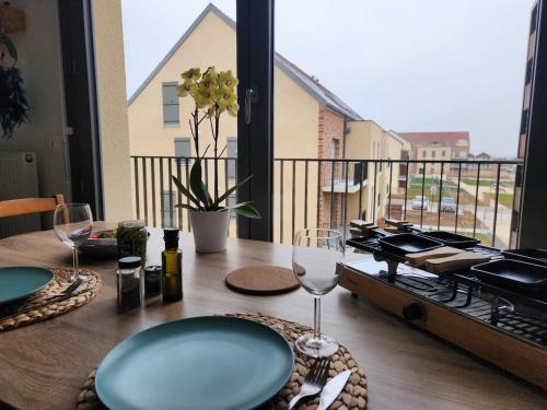 une table avec des assiettes et des verres à vin sur un balcon dans l'établissement Bali Forest Roissy CDG Airport - Paris Villepinte, à Marly-la-Ville