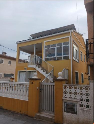 a yellow house with a white railing at Casa a 200 metros de la playa 10 PAX in Almazora