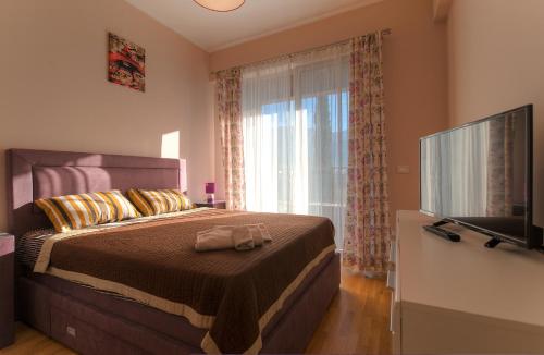 a bedroom with a bed with a large window at Sea View Apartments MonteBook in Becici
