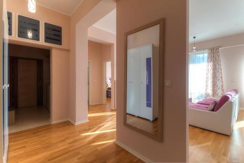 a living room with a mirror and a couch at Sea View Apartments MonteBook in Becici