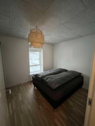 a bedroom with a bed and a window and a ceiling at ATCON Business Apartments in Nuuk