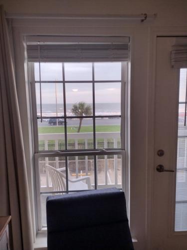 a window with a chair and a view of the ocean at Ocean Front Condo - 3 Bdrms - Hot Tubs - 2 Pools - Gym - Tennis ct - SS2203 in Galveston