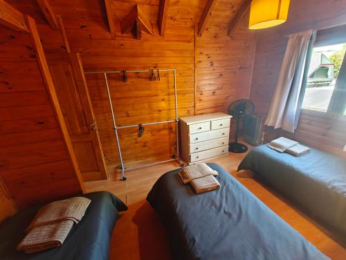 a bedroom with two beds in a wooden cabin at Cabaña San Martín de los Andes in San Martín de los Andes