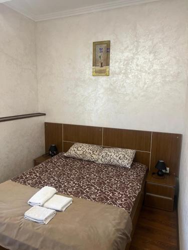 a bedroom with a bed with two towels on it at Grand Hotel in Mohyliv-Podilʼsʼkyy