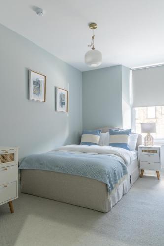 a white bedroom with a bed and a window at Prime Stay Apartments in Paisley