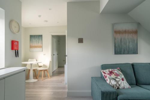 a living room with a green couch and a table at Prime Stay Apartments in Paisley