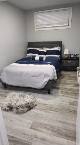 a bedroom with a bed and a rug on the floor at Mercy's lodge in Saskatoon
