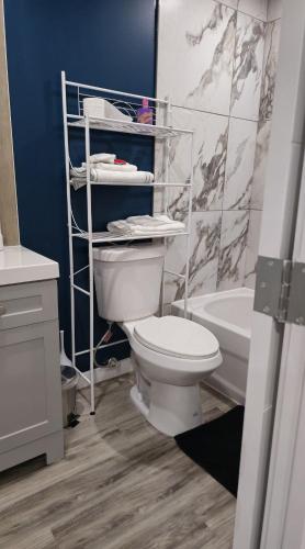 a bathroom with a toilet and a sink and a tub at Mercy's lodge in Saskatoon