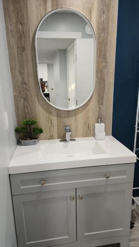 a bathroom with a white sink and a mirror at Mercy's lodge in Saskatoon