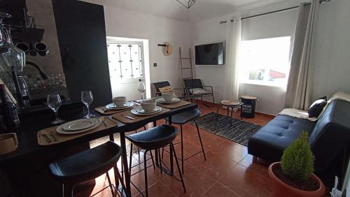 ein Wohnzimmer mit Tisch und Stühlen und einer Couch in der Unterkunft Bougainvillea House in Ponta do Pargo