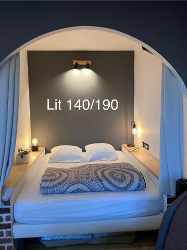 un lit avec un panneau lumineux sur le mur dans l'établissement Studio cocon sur front de mer, au Barcarès