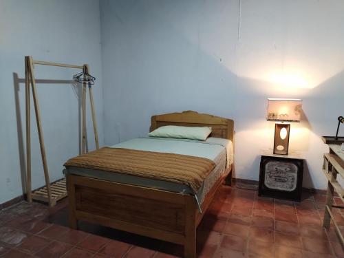 Un dormitorio con una cama y una lámpara sobre una mesa. en CASA LICHIs, en Suchitoto