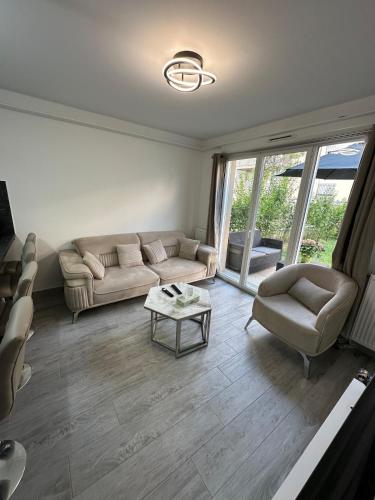 un salon avec un canapé et une table dans l'établissement Villa normande, à Villeneuve-le-Roi