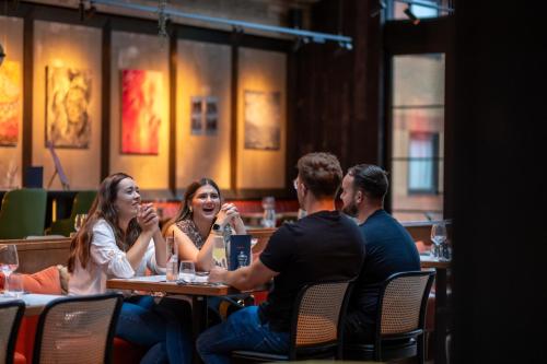 a group of people sitting at a table in a restaurant at Burleigh Court Hotel and Leisure in Loughborough
