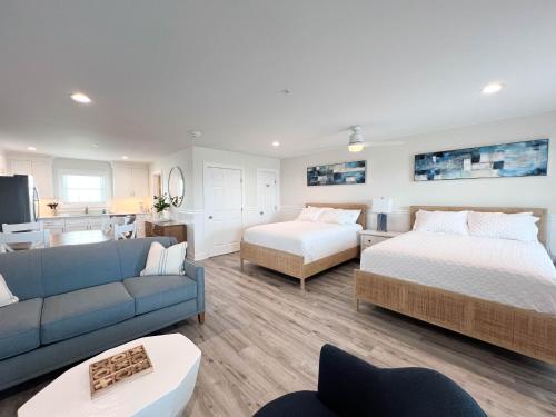 a living room with two beds and a blue couch at 3002 Queen Suite, 3rd Floor Surfside in Surf City